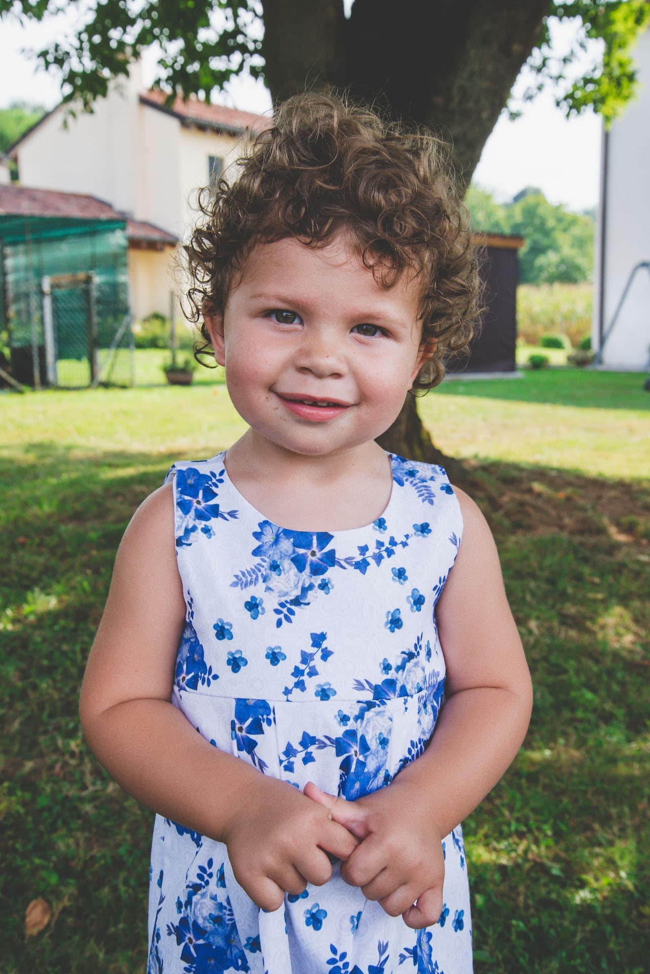 bambina giardino sorriso vestito a fiori