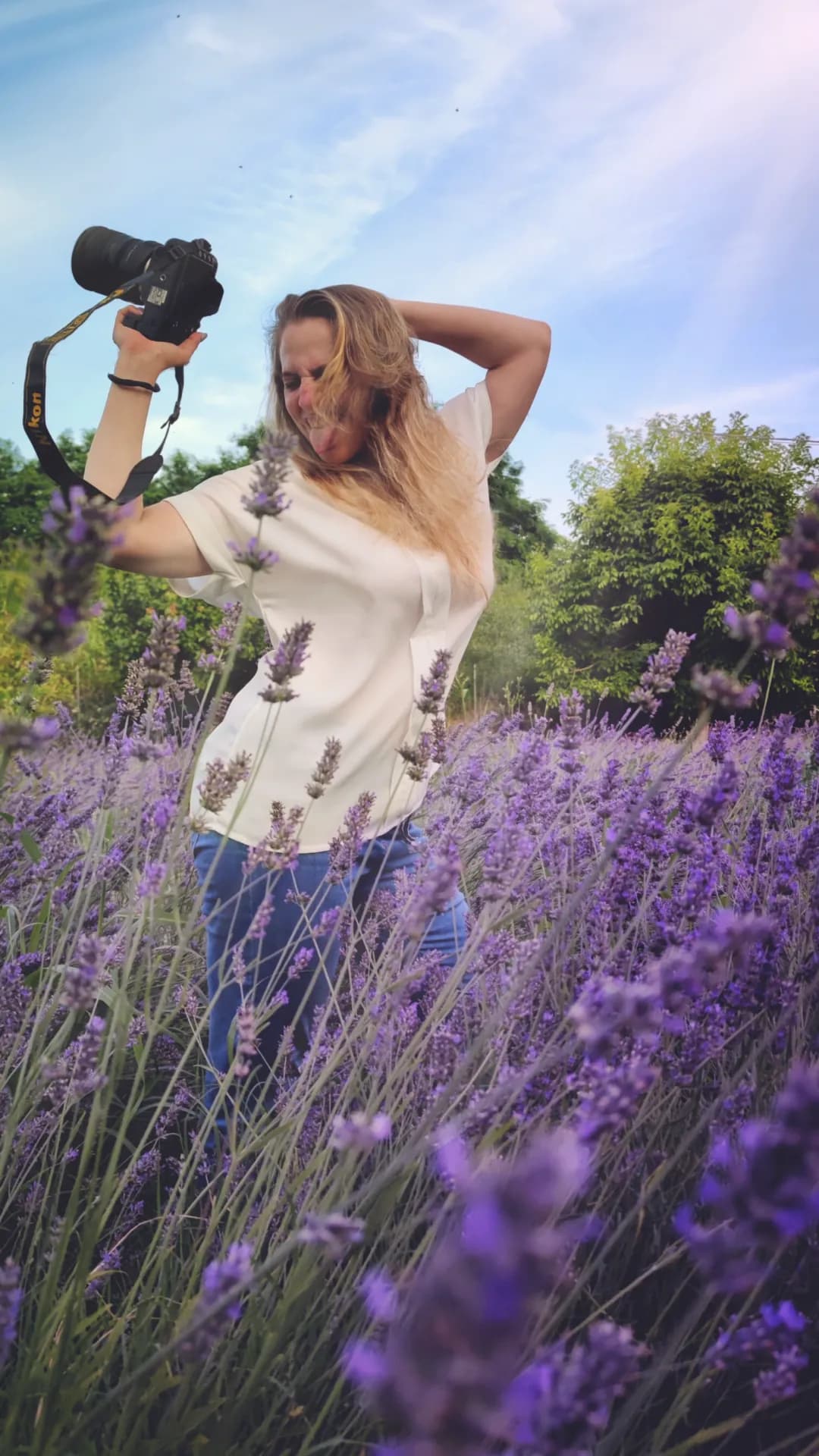 Giulia in un campo di lavanda con la macchina fotografica sollevata