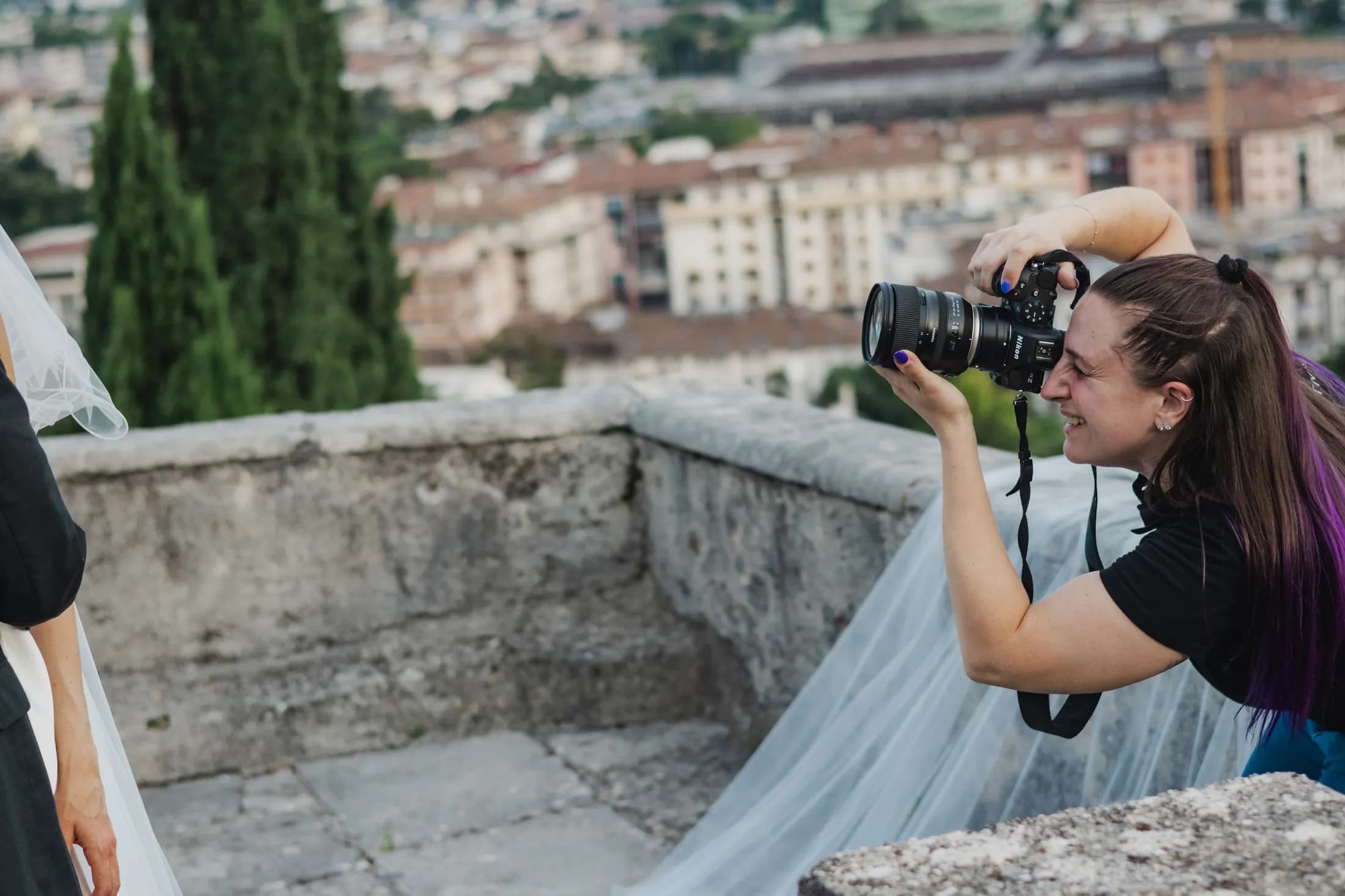 Giulia fotografa una sposa su una terrazza affacciata sulla città