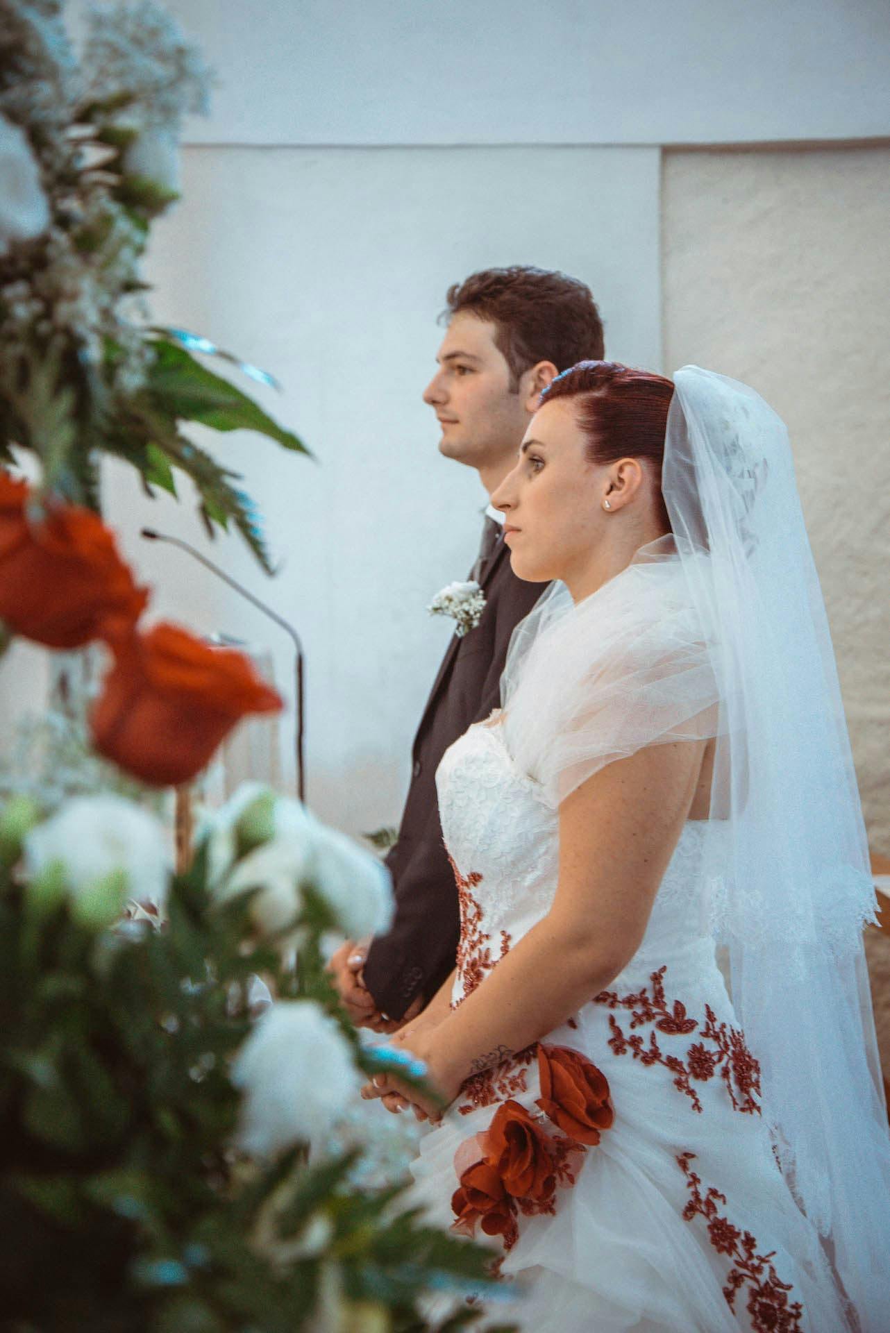 sposi altare vestito bianco rosso rose